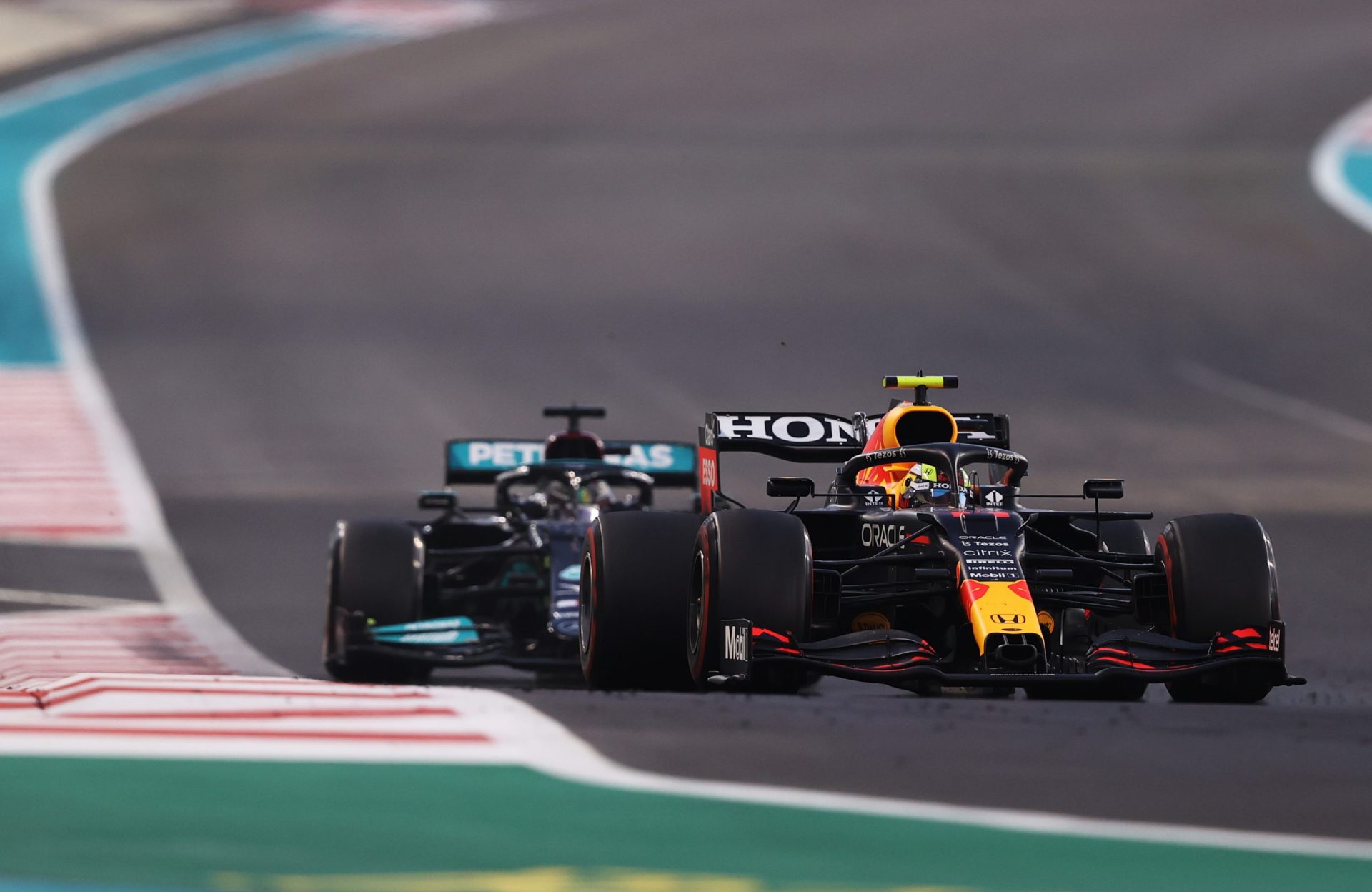 ABU DHABI, UNITED ARAB EMIRATES - DECEMBER 12: Sergio Perez of Mexico driving the (11) Red Bull Racing RB16B Honda leads Lewis Hamilton of Great Britain driving the (44) Mercedes AMG Petronas F1 Team Mercedes W12 during the F1 Grand Prix of Abu Dhabi at Yas Marina Circuit on December 12, 2021 in Abu Dhabi, United Arab Emirates. (Photo by Lars Baron/Getty Images) // Getty Images / Red Bull Content Pool  // SI202112120208 // Usage for editorial use only //